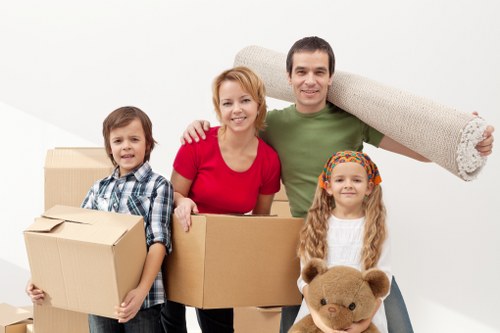 Professional movers carrying furniture through a narrow Hackney staircase
